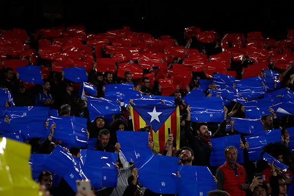 Aficionado muestra una bandera de Catalunya entre las cartulinas