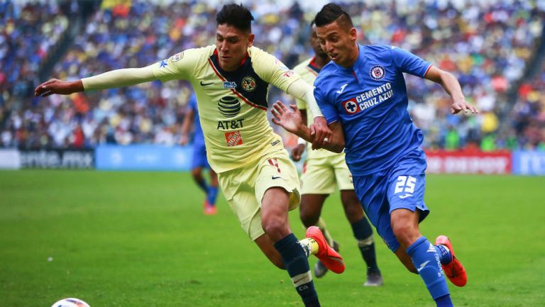 Edson Álvarez y Roberto Alvarado disputan un balón