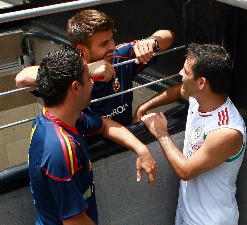 Xavi, Piqué y Rafa Márquez platican antes de un amistoso