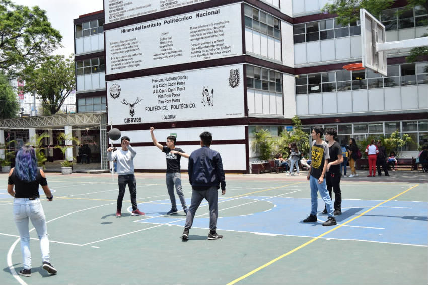 Alumnos juegan basquetbol en el patio del plantel 