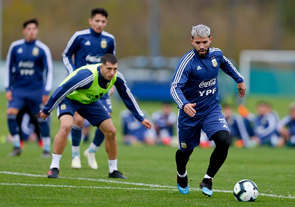 Kun maneja el balón ante la mirada de Guido Rodríguez