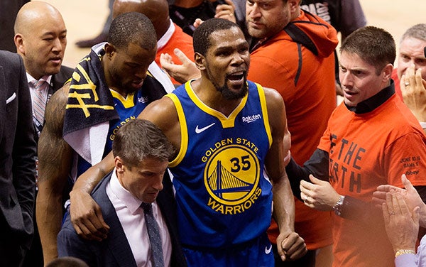 Durant sale de la duela ayudado por personal de los Warriors