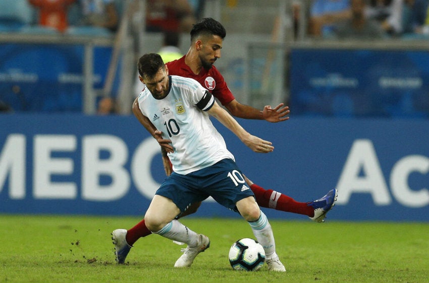 Messi protege el balón de un rival 