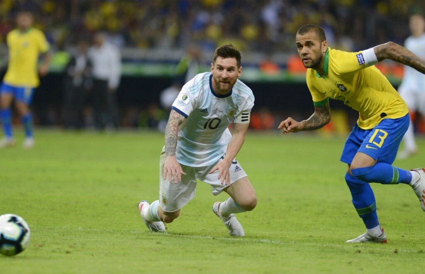 Messi y Alves pelean por el balón 