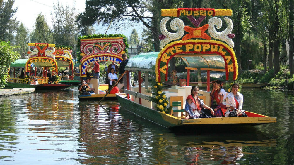 Trajineras de Xochimilco navegando sobre el canal