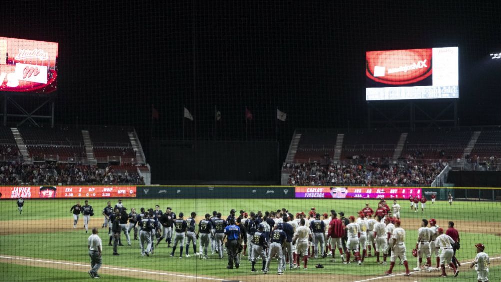 Jugadores de Tigres y Diablos Rojos en el diamante 