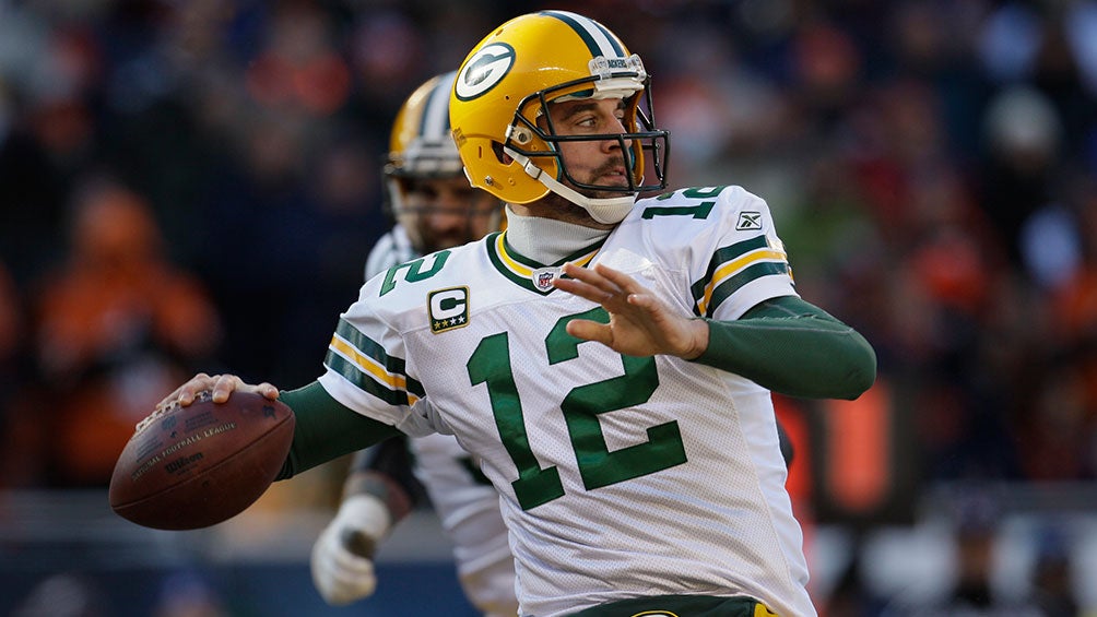 Aaron Rodgers a punto de lanzar un pase en un partido con los Green Bay Packers