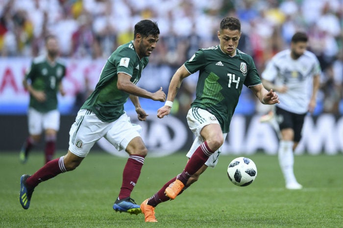 Vela y Chicharito conducen el balón 