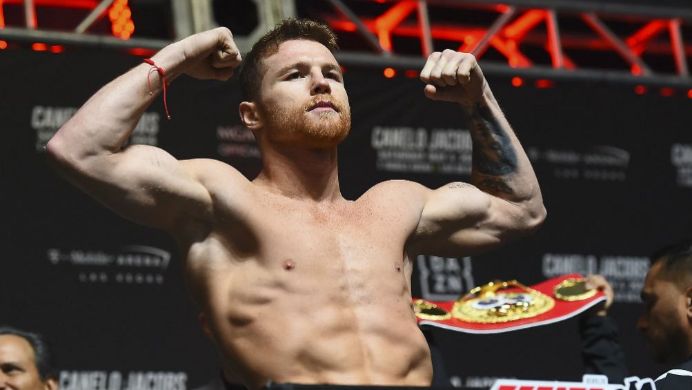 Canelo levanta los brazos en una ceremonia de pesaje 