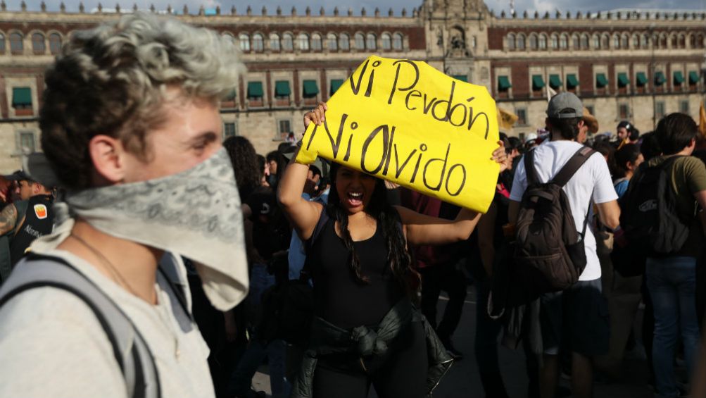 Mujer con un letrero en el Zócalo de la CDMX