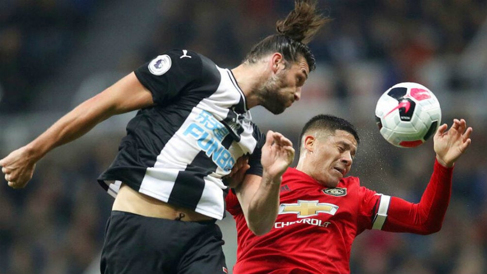 Andy Caroll y Marcos Rojo disputando un balón 