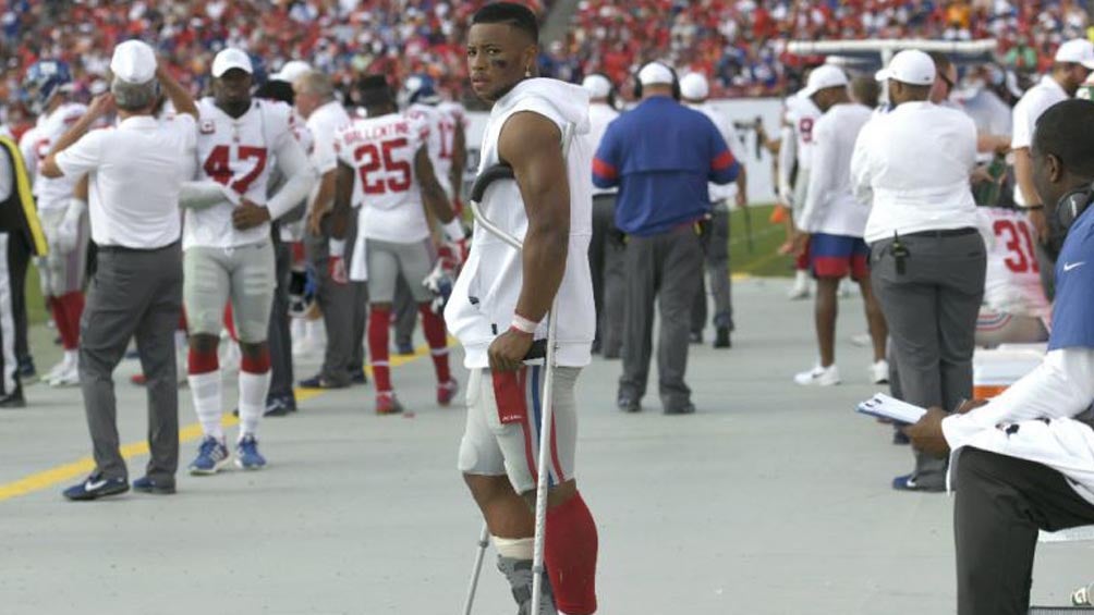 Saquon Barkley con muletas tras lesionarse