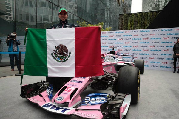 Checo Pérez posa con su casco y monoplaza 