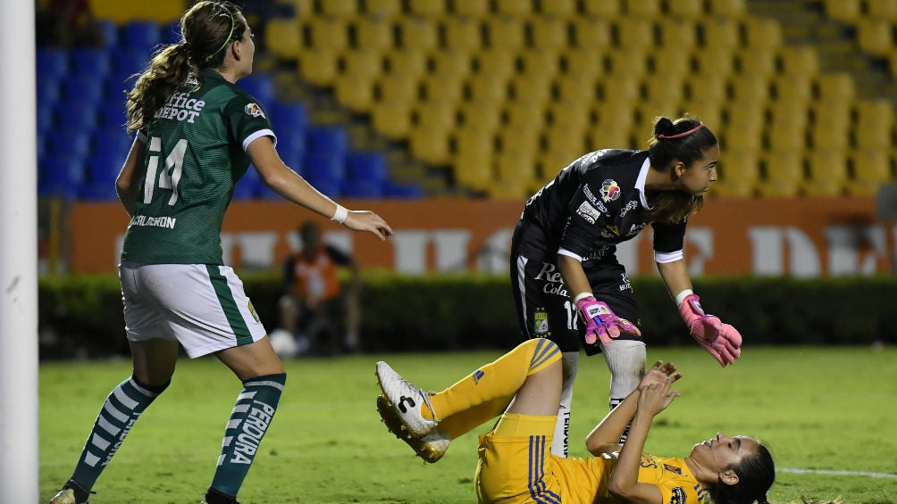 La portera del León observa a una jugadora de Tigres en el césped