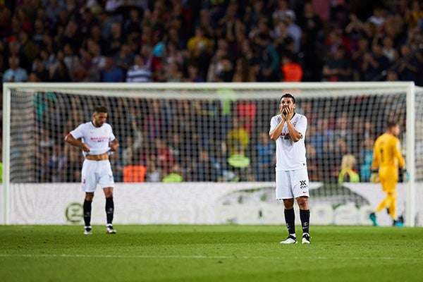 Jugadores del Sevilla se lamentan en partido contra Barcelona