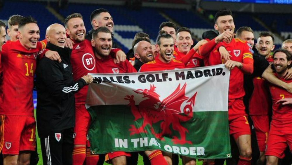 Gareth Bale sosteniendo con sus compañeros la bandera de Gales