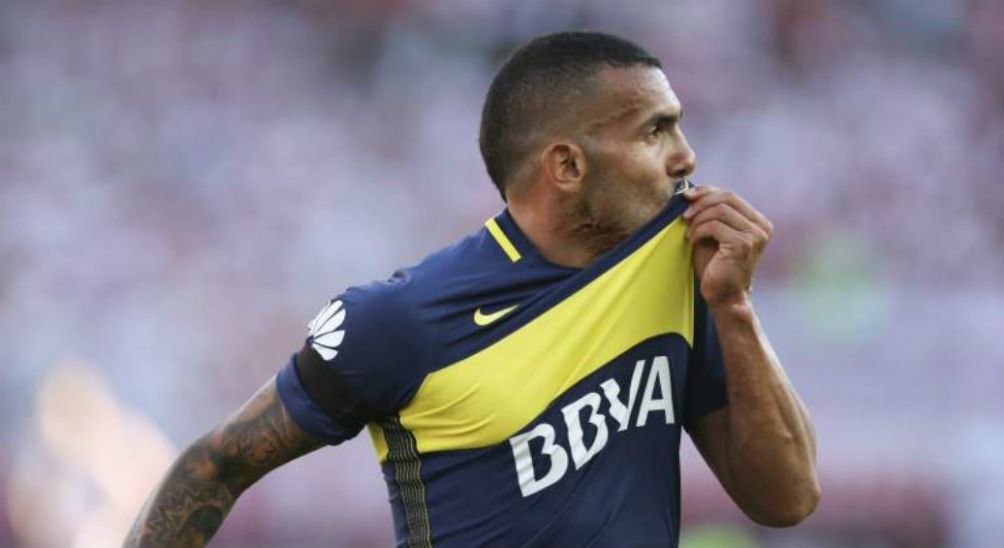 Carlos Tevez celebrando una anotación besando el escudo de Boca