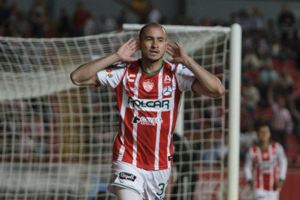 Carlos González celebrando una anotación como jugador de Necaxa