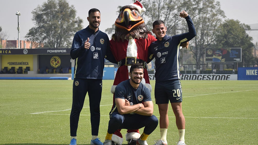 Los jugadores de América, con la mascota disfrazada de Santa Claus