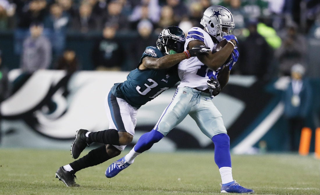 Michael Gallup de Cowboys recibiendo un pase, mientras Jalen Mills defiende