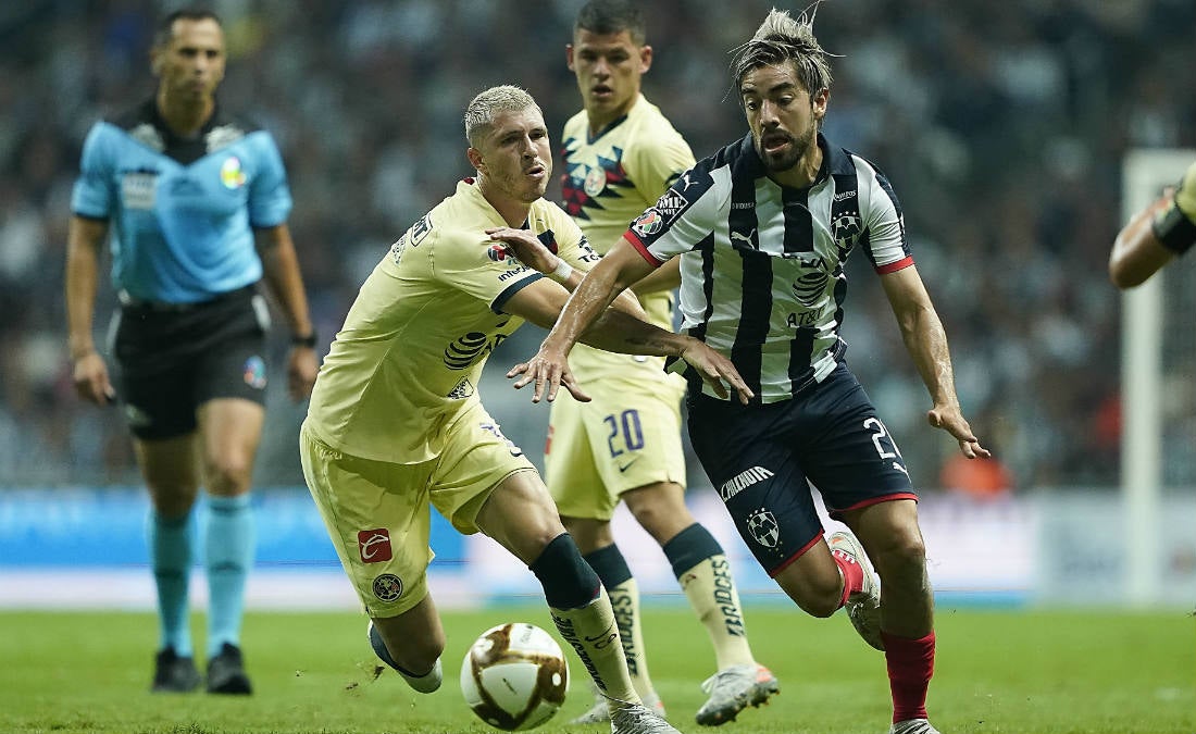 Guido Rodríguez peleando un balón con Rodolfo Pizarro