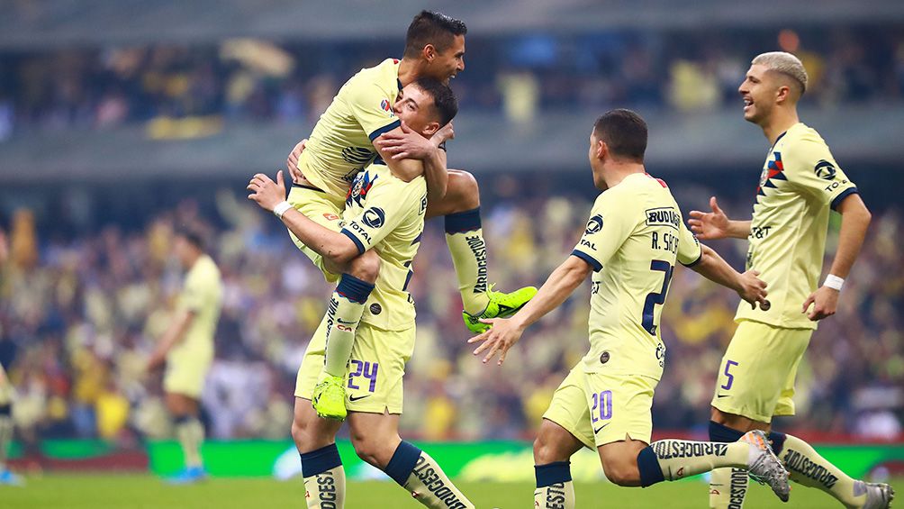 Jugadores de América festejan un gol 