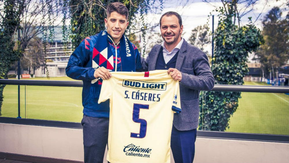 Santiago Cáseres posando con la playera del América