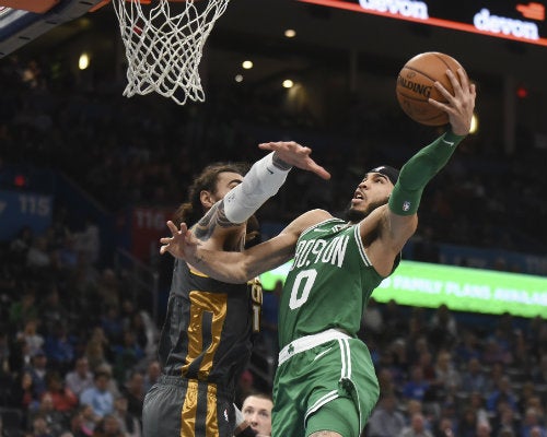 Jayson Taytum intenta encestar el balón sobre Steven Adams