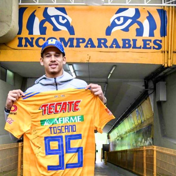 Juan Toscano posando con la playera de Tigres