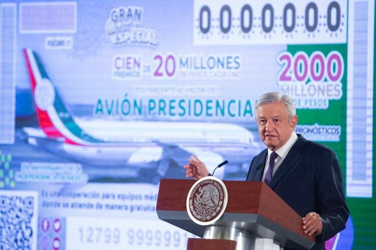 AMLO presentando el boleto de la rifa del avión