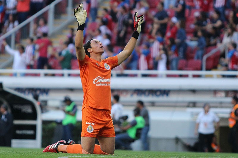 El portero de Chivas alza los brazos al cielo durante un encuentro