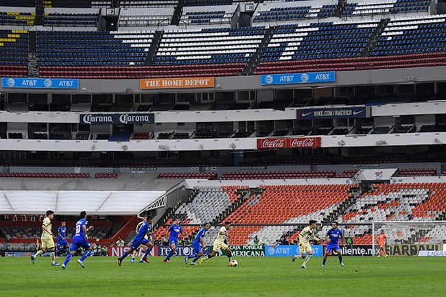 Jugadores de América y Cruz Azul con el Azteca vacío de fondo