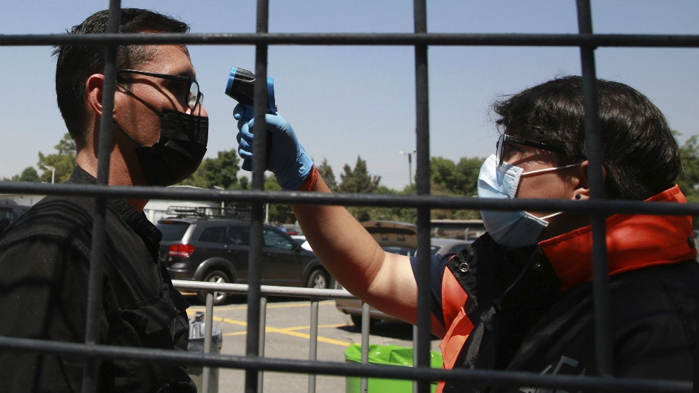 Hombre que le miden la temperatura previo a entrar al Vive Latino