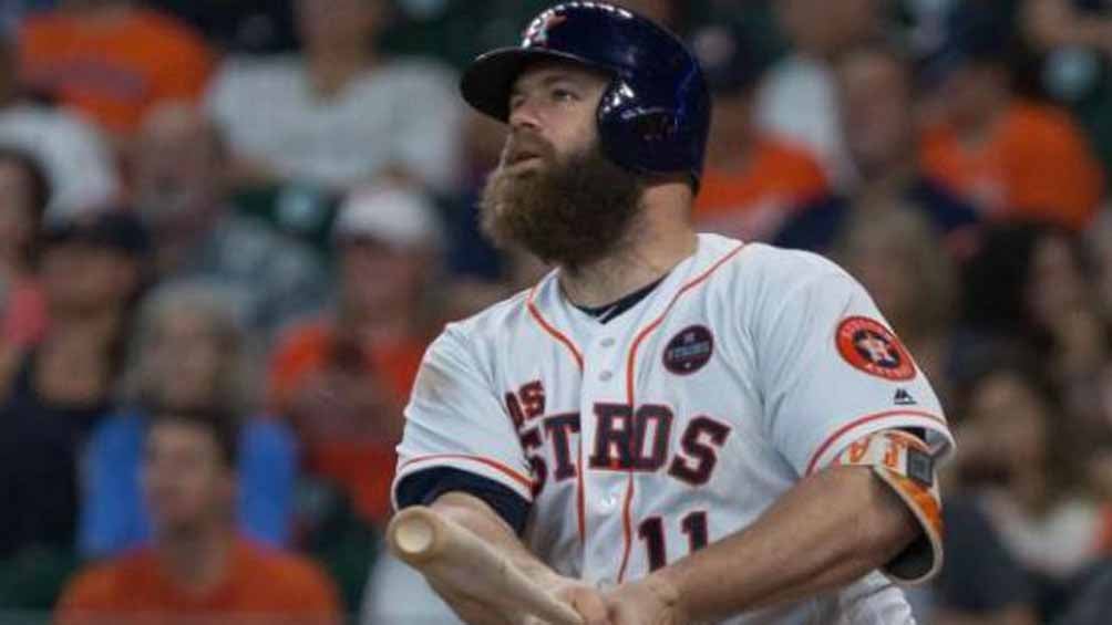 Evan Gattis observa la pelota tras impactarla