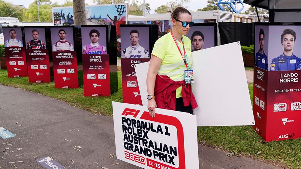 Una mujer retira carteles del GP de Australia