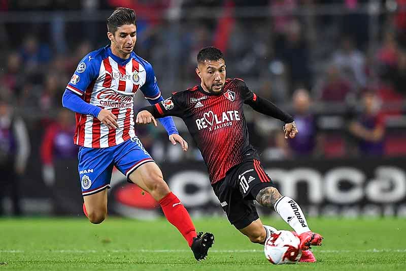 Brizuela y Acosta disputan un balón en el Clásico Tapatío 