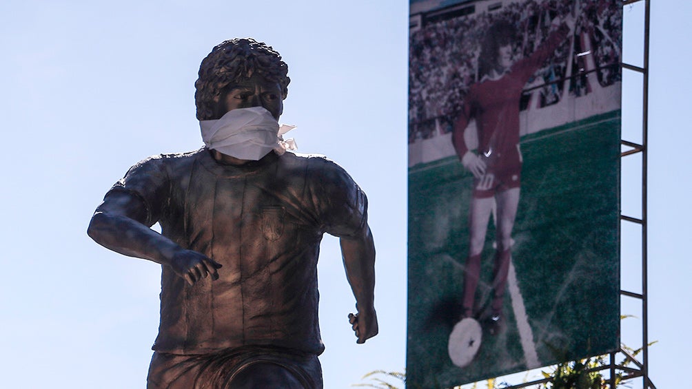 Escultura de Maradona con el cubrebocas en las afueras del inmueble