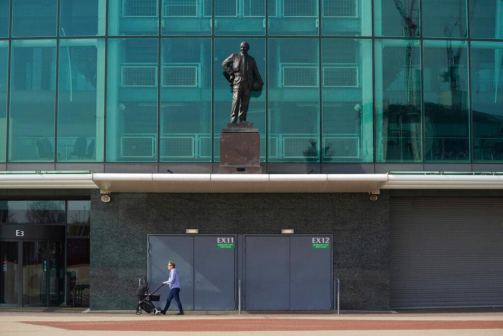  Una persona empuja una carriola frente a un vacío Old Trafford