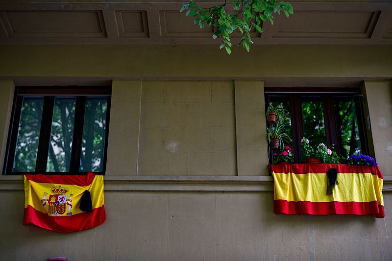 Las banderas de España cuelgan desde el balcón de una casa