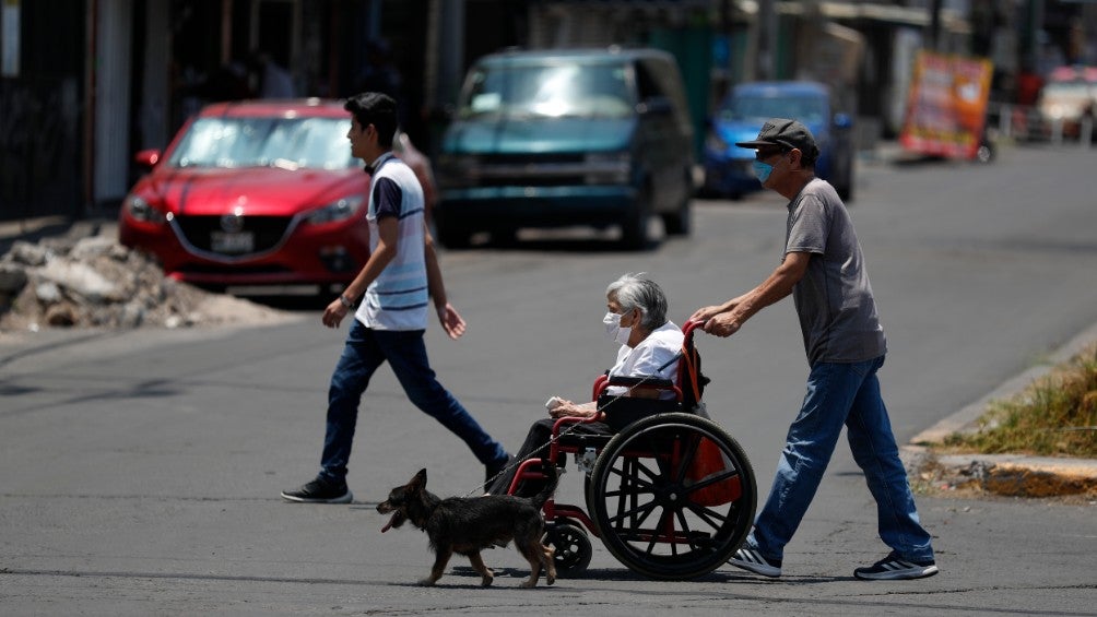 Hombre empuja a una mujer en una silla de ruedas en CDMX