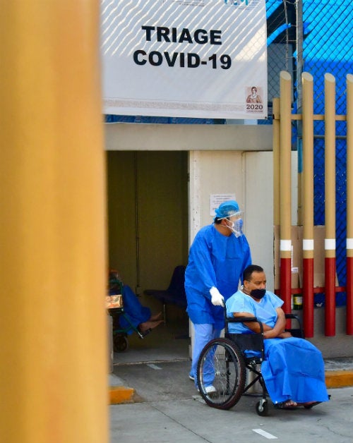 Una enfermera traslada a un paciente dado de alta del COVID-19