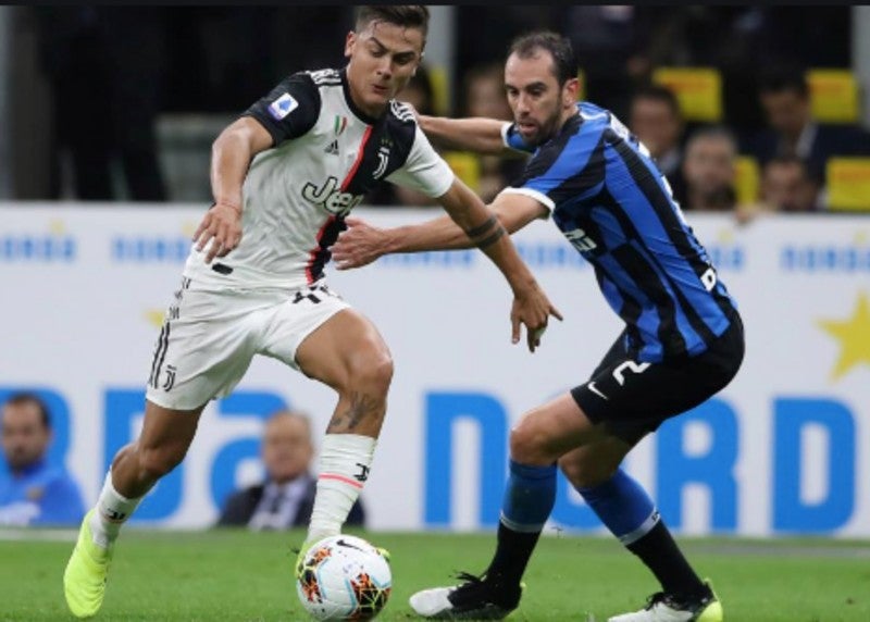 Dybala encarando a Godin en un juego de la Serie A