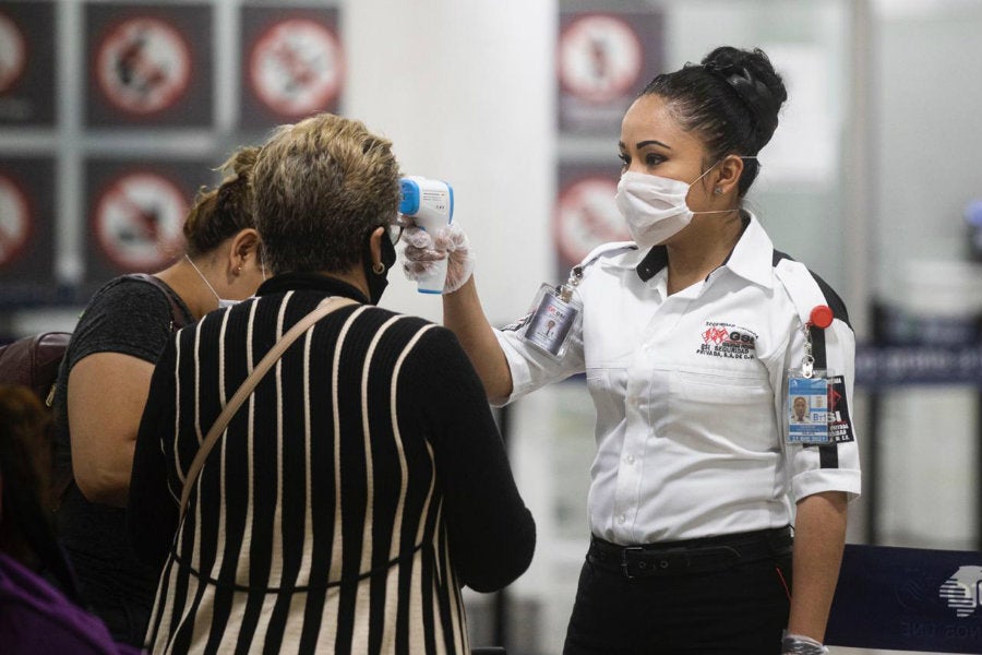 Toma de temperatura a mujer en el Aeropuerto Internacional de la Ciudad de México