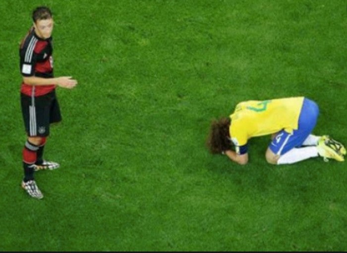 Mesut Özil observa a un destruído David Luiz