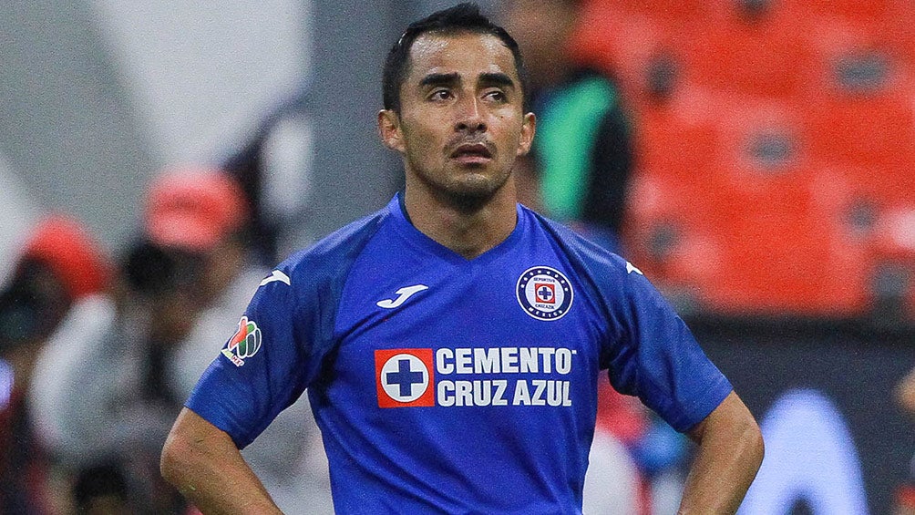 Baca se arrodilla en el césped durante un juego de Cruz Azul