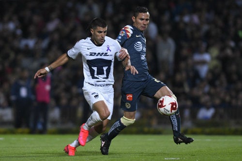 El argentino y Paul Aguilar disputan un balón