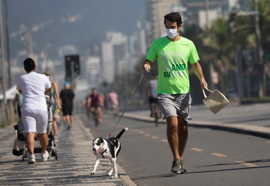 Hombre camina con su perro en Rio de Jainero