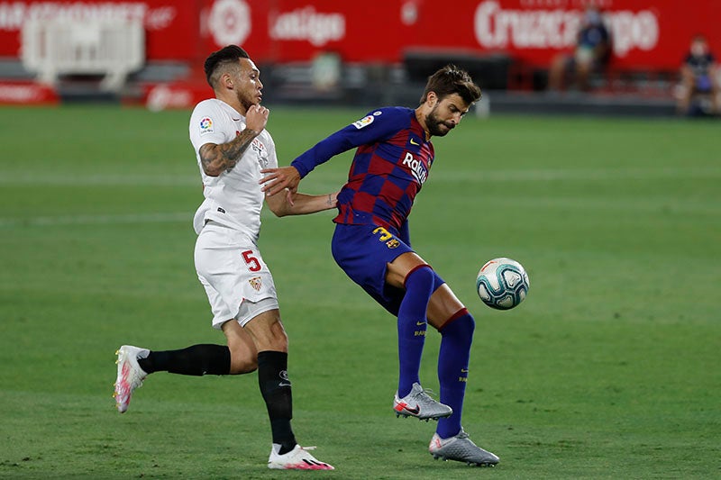 Piqué pelea un balón con Ocampos en el Sevilla-Barcelona 