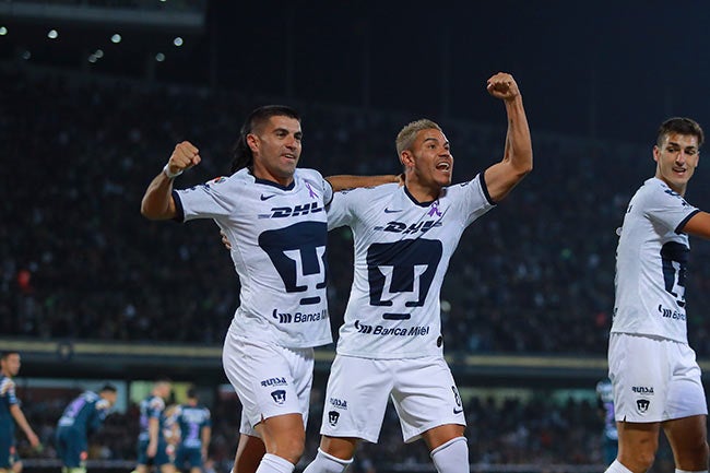 Barrera festeja un gol de Pumas junto a Malcorra