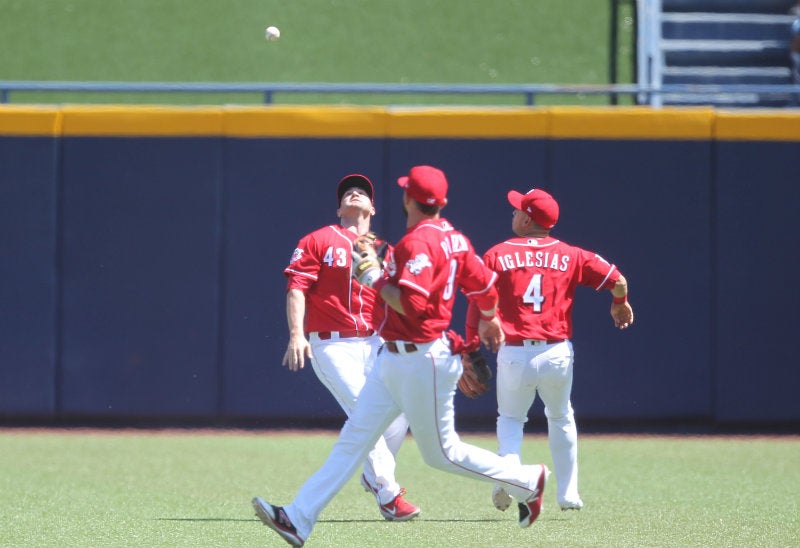 Jugadores de Reds tratando de atrapar la bola